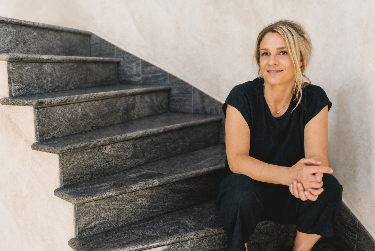 Mia Schwaiger sitzt auf einer hellen Treppe